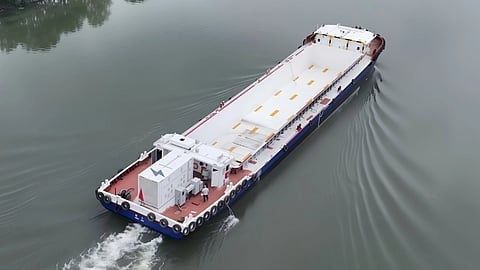 Elektrisch ogend vrachtschip vaart over een rustige rivier